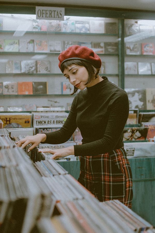 Retrato de mujer en tienda de vinilos buscando un disco