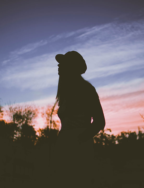 Retrato de mujer en atardecer usando sombras y baja exposición