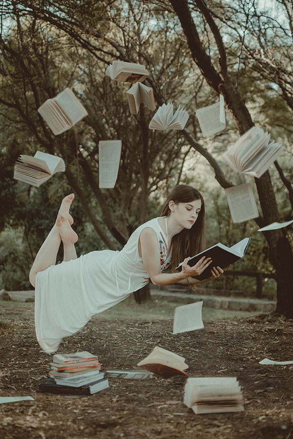 Retrato de mujer en el aire con libros volando